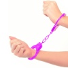 Pevné kovové putá neónovo fialovej farby s bezpečnostou poistkou a dvoma kľúčikmi nasadené na rukách.