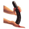 Detail na veľké čierne dildo s výraznou žilnatosťou v rukách.