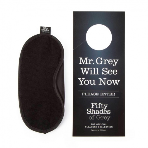Čierna maska na oči s ceduľou na dvere ako súčasť balenia pút o dvere Fifty Shades of Grey.