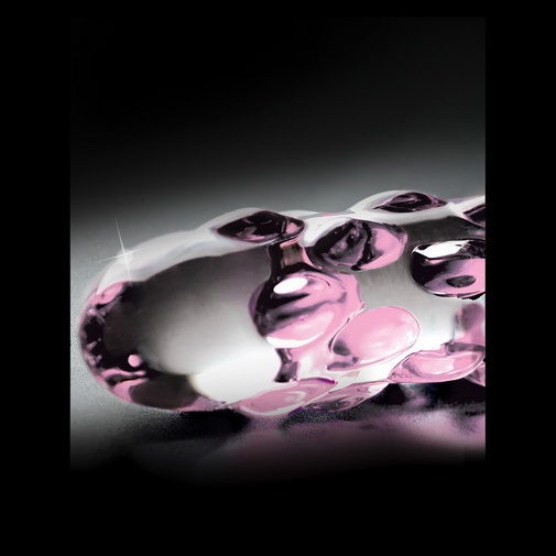 Detail zblízka na sklenené dildo s ružovými výstupkami.