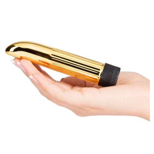 Detail na veľkosť malého zlatého vibrátora v ženských rukách.
