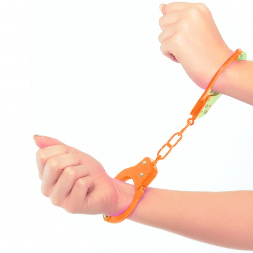 Pevné kovové putá neónovo oranžovej farby s bezpečnostou poistkou a dvoma kľúčikmi nasadené na rukách.