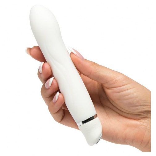 Vodotesný biely vibrátor pevnej konštrukcie v ženskej ruke.