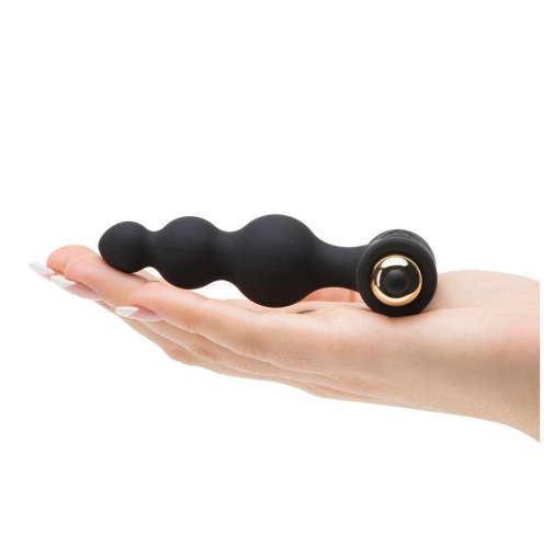 Bubbles Petite Sensations vibračný guľôčkový kolík čiernej farby položený na dlani.