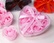 Ružové lupene ruží v peknom darčekovom balení v tvare srdca so stuhou.