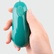 Malé vibračné vajíčko zelenej farby v ruke.